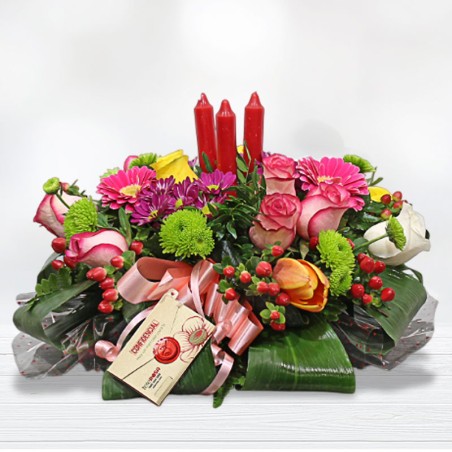 A centerpiece that combines roses and lilies with the glow of 3 candles